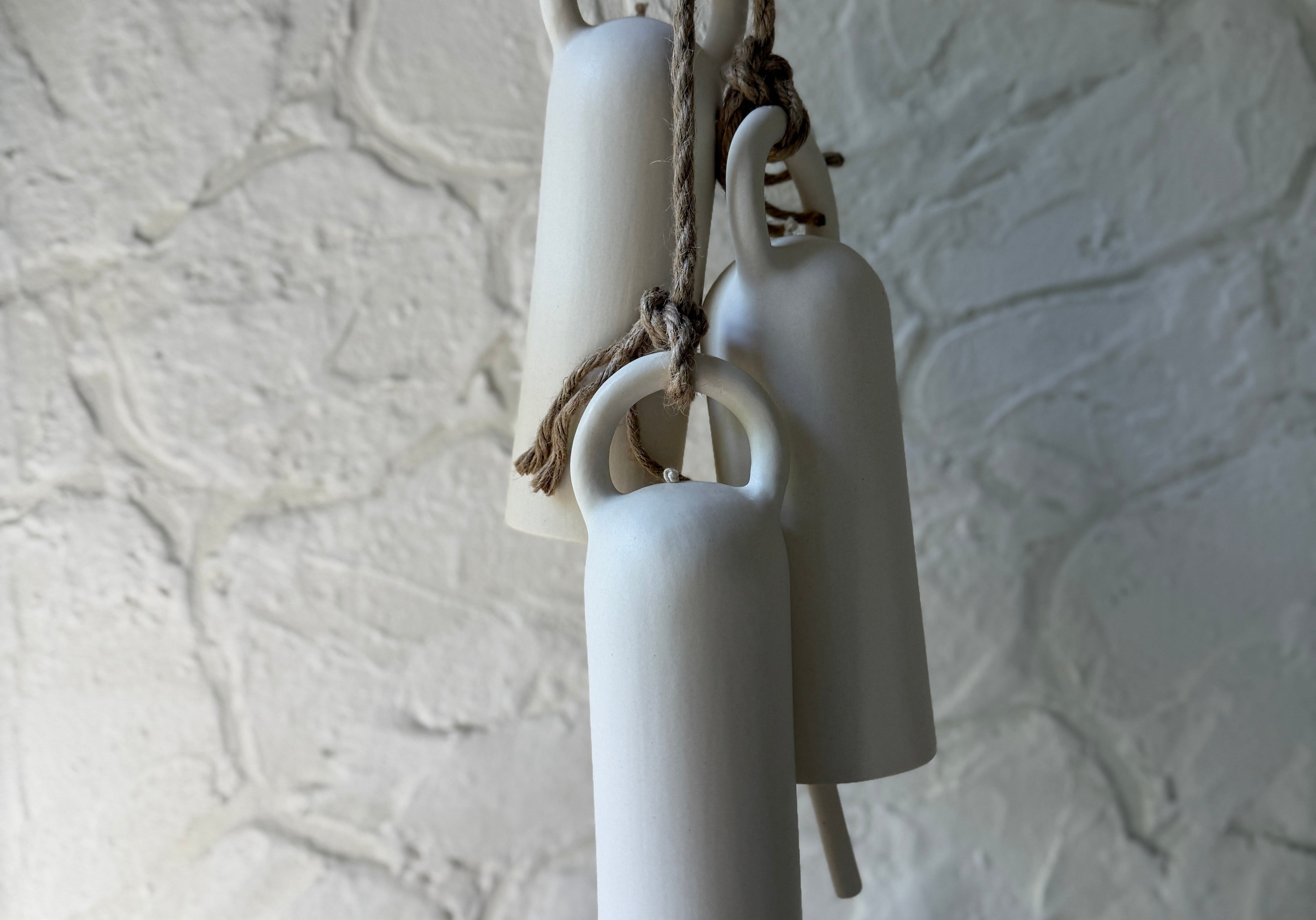 Handmade ceramic bells styled together, a wide editorial view