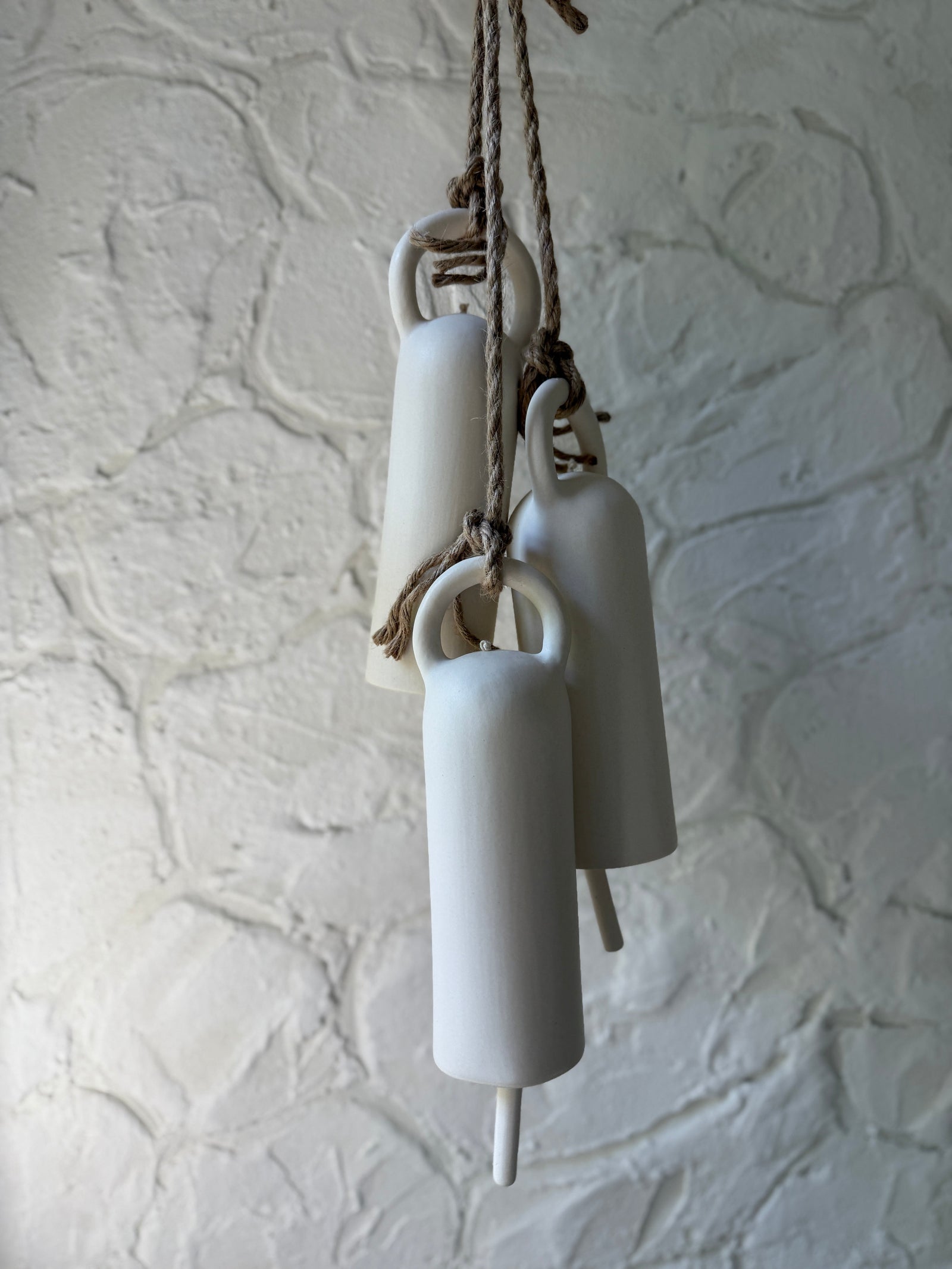 Handmade ceramic bells styled together, a wide editorial view