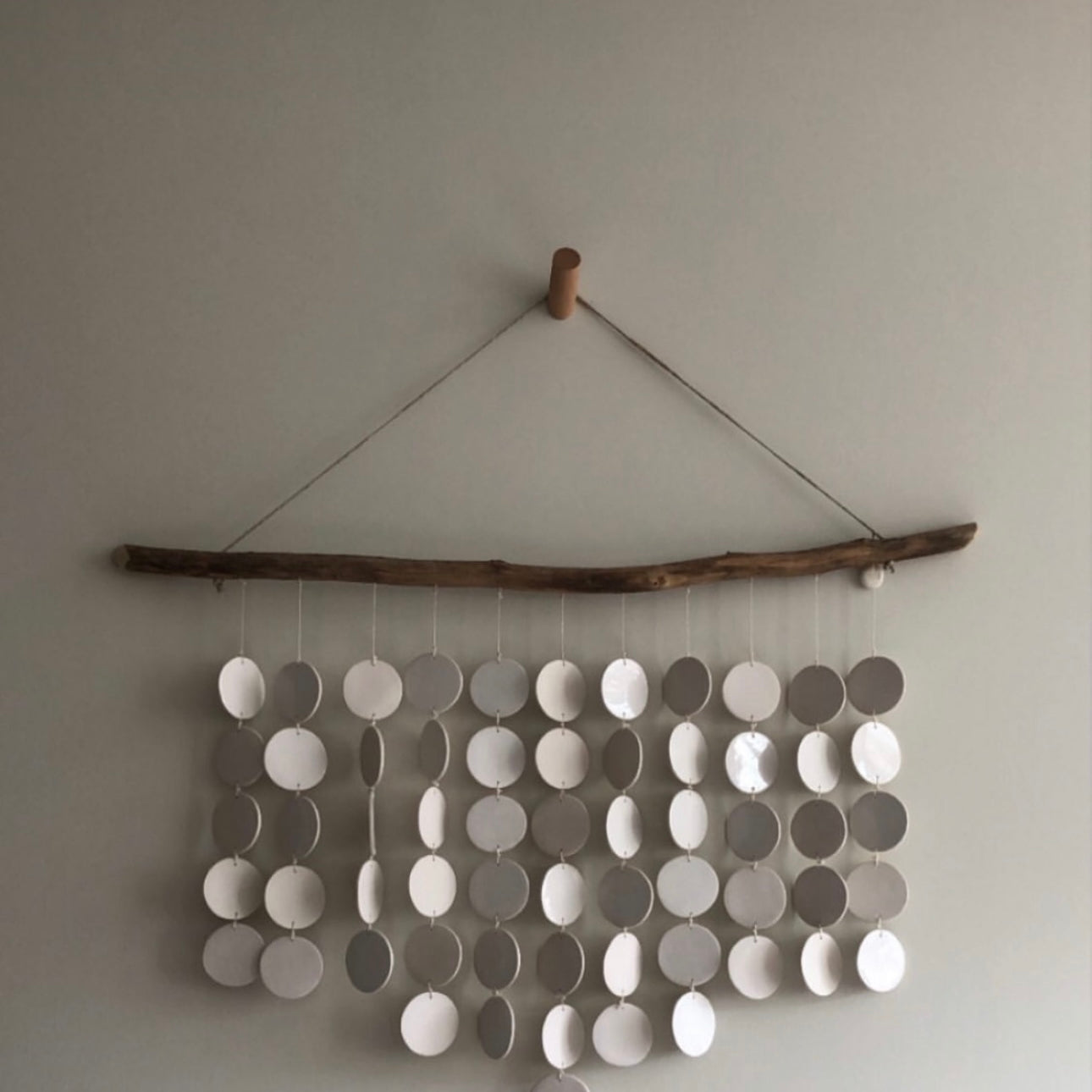 Handmade driftwood and ceramic disc wall hanging with white discs