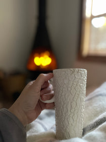 Handmade tall ceramic mug with delicate lace texture