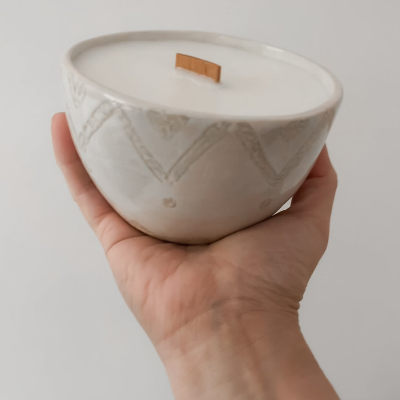 Stylish hand-poured soy candle with vanilla scent and ceramic bowl