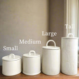 Staggered ceramic canisters set in custom colors and sizes