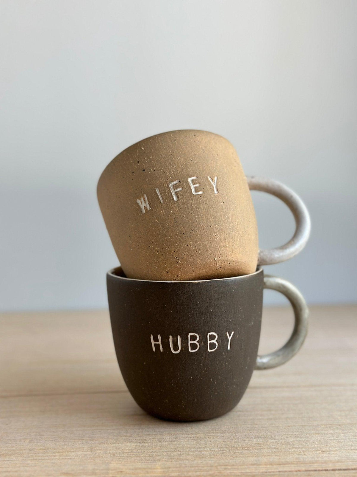 Handmade Hubby and Wifey ceramic mugs personalized for couples in a neutral glaze