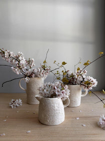 Handmade ceramic pouring vessel with a raw clay exterior, watertight for flowers or storage